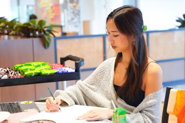 A woman painting on her own at a studio table, mixing green acrylic
