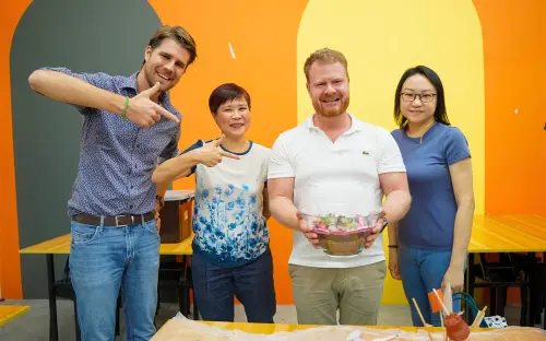 Four colleagues with the terrarium they built together
