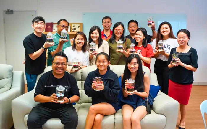 A corporate team poses with their finished terrariums