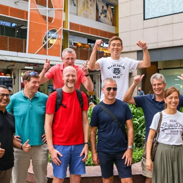 A team of eight cheer outside a row of shops