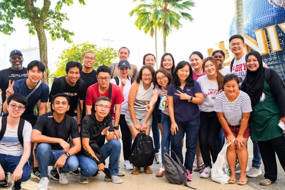 A big group pose together under the palm trees at Sentosa