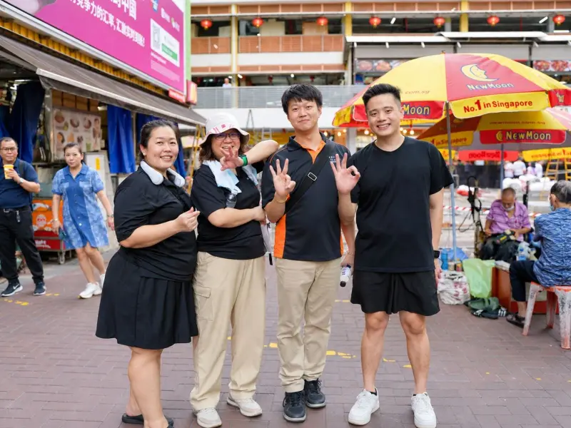 Four teammates pose on a Chinatown market street