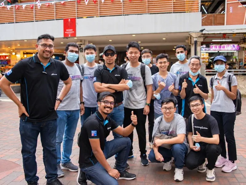A group of colleagues pose together in a Chinatown plaza