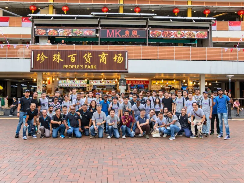 A very large group pose in front of People&rsquo;s Park Complex