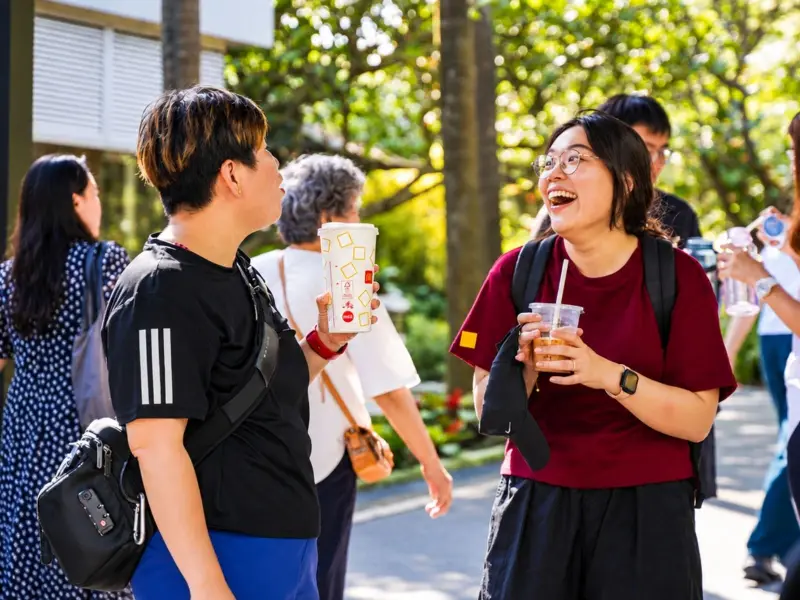 Teammates laugh together with drinks between stations