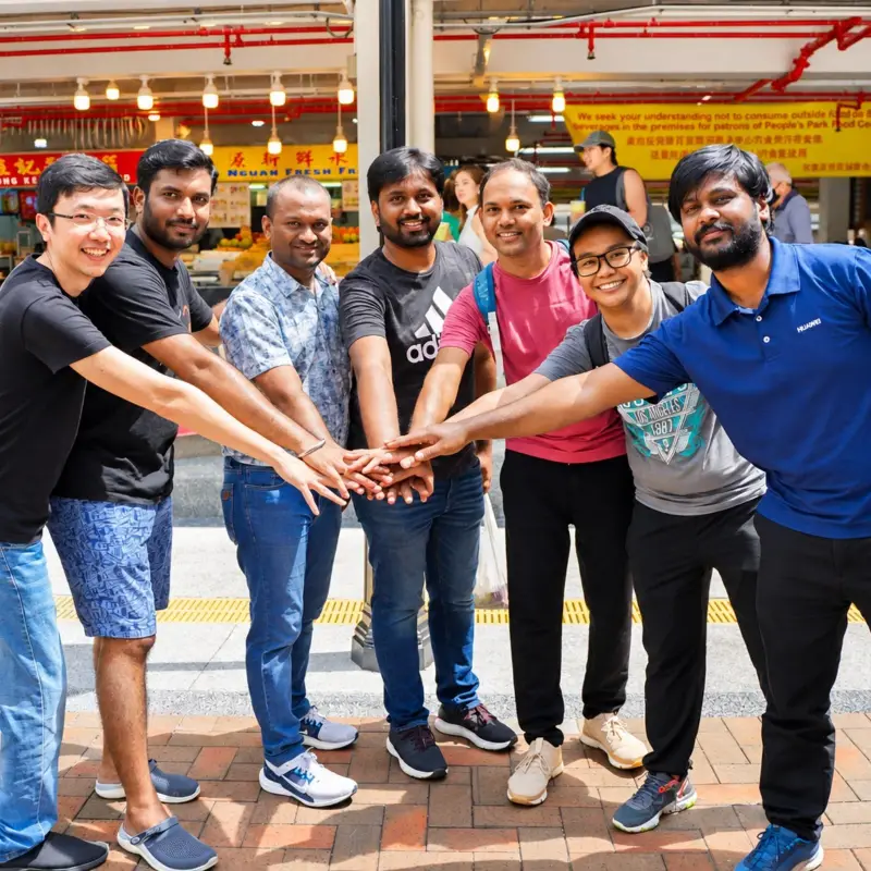 A team of colleagues join hands before setting off through Chinatown