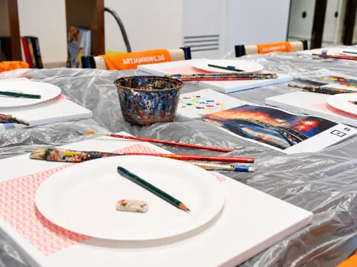 Canvases, paper-plate palettes, pencils and brushes set out ready to paint