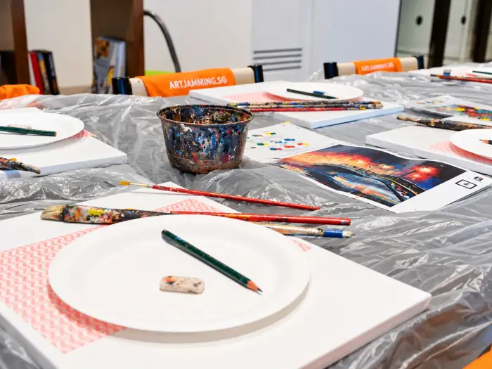Canvases, paper-plate palettes, pencils and brushes set out ready to paint