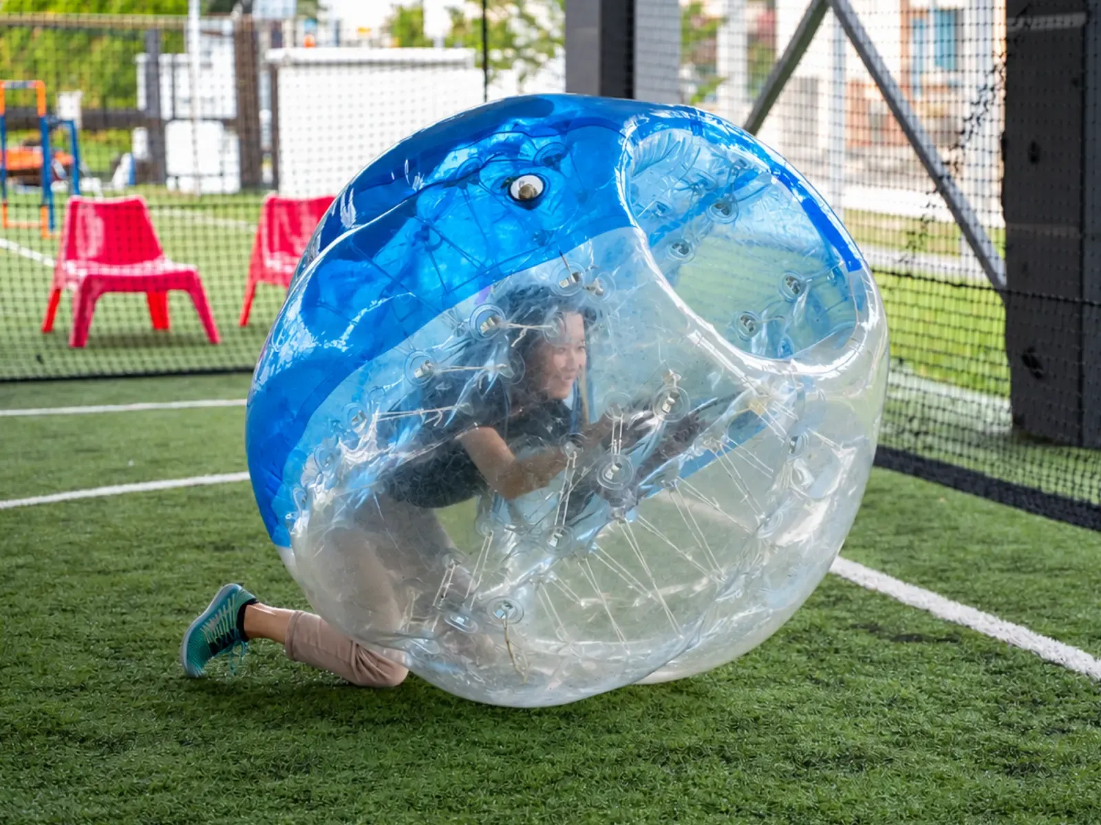 A player crouches inside a clear and blue bubble suit