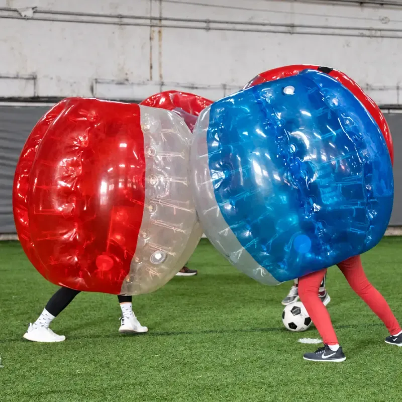 Two players in bubble suits with the ball between them