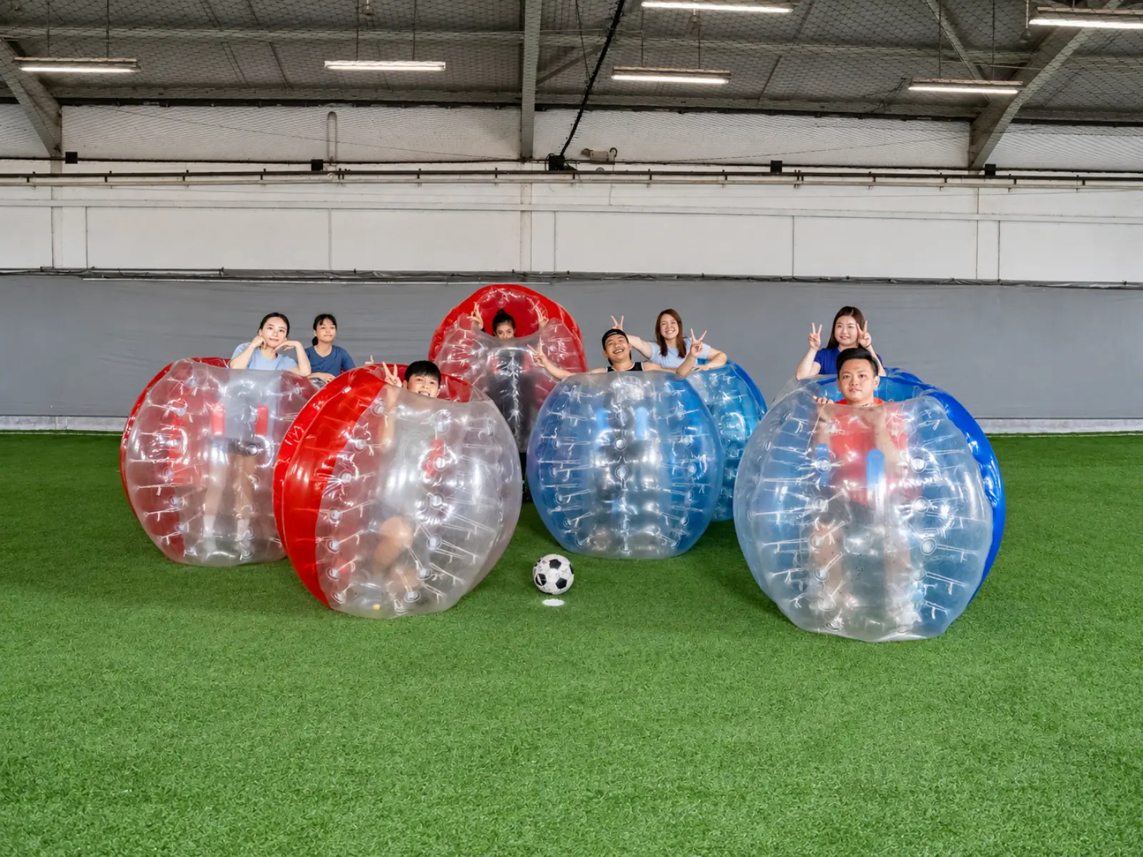 A group crouches behind their bubble suits for a photo