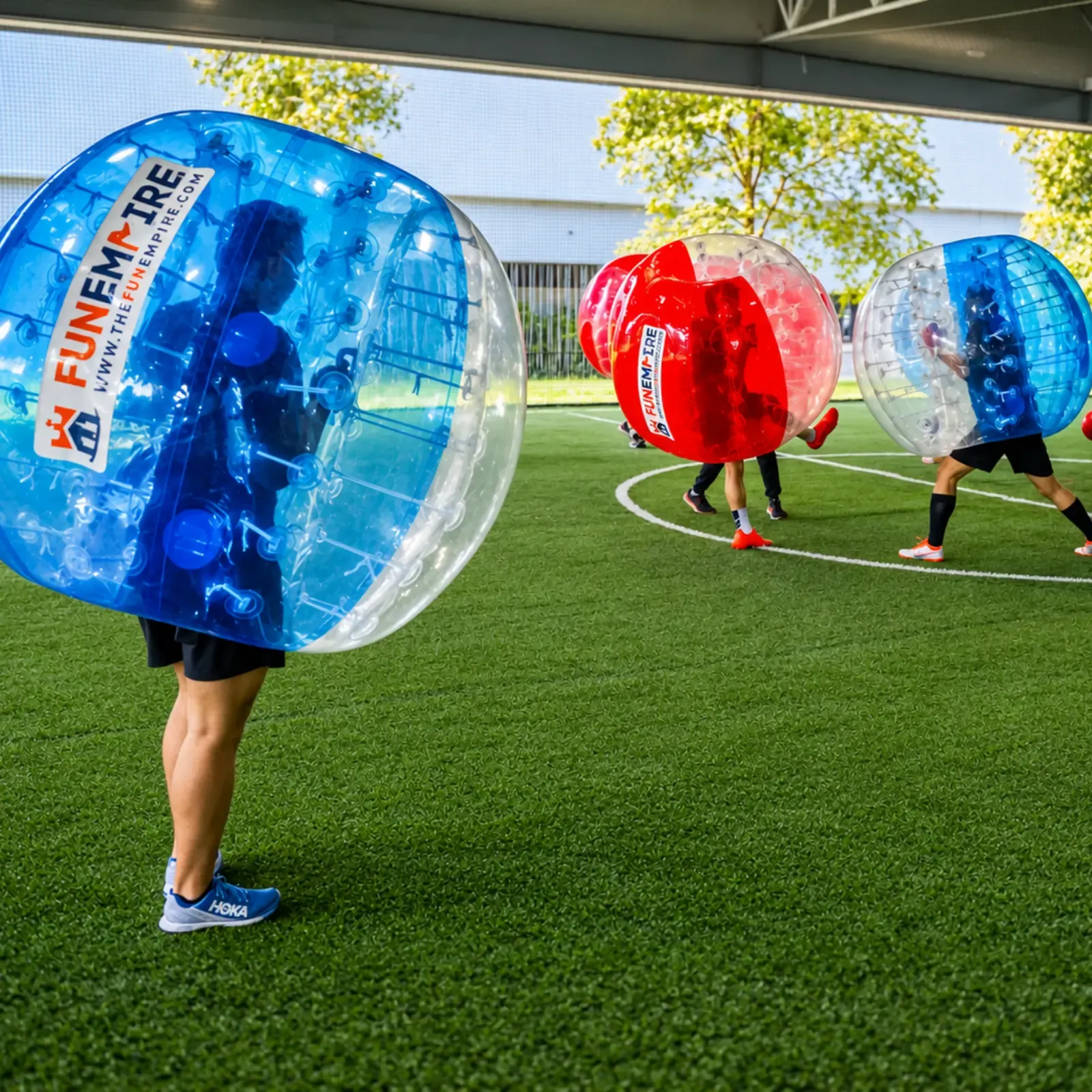 Colleagues playing Bubble Soccer on an outdoor pitch