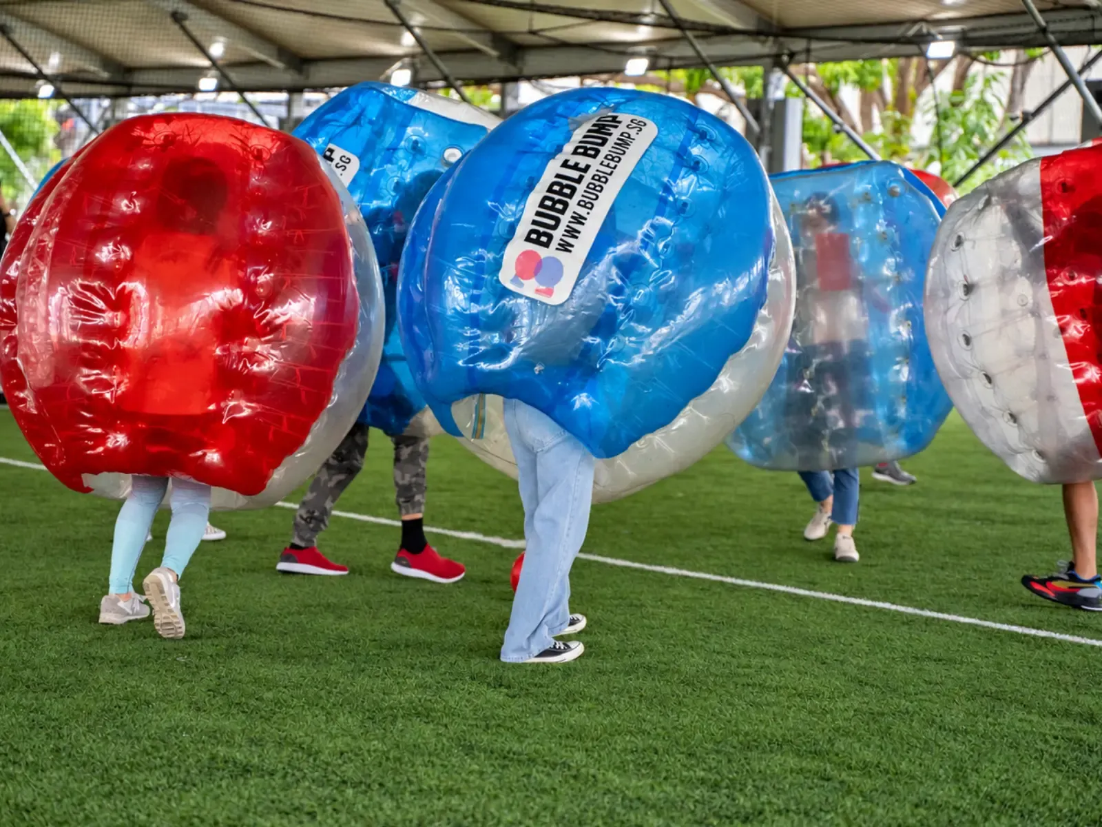 Two players collide hard in red and blue bubble suits