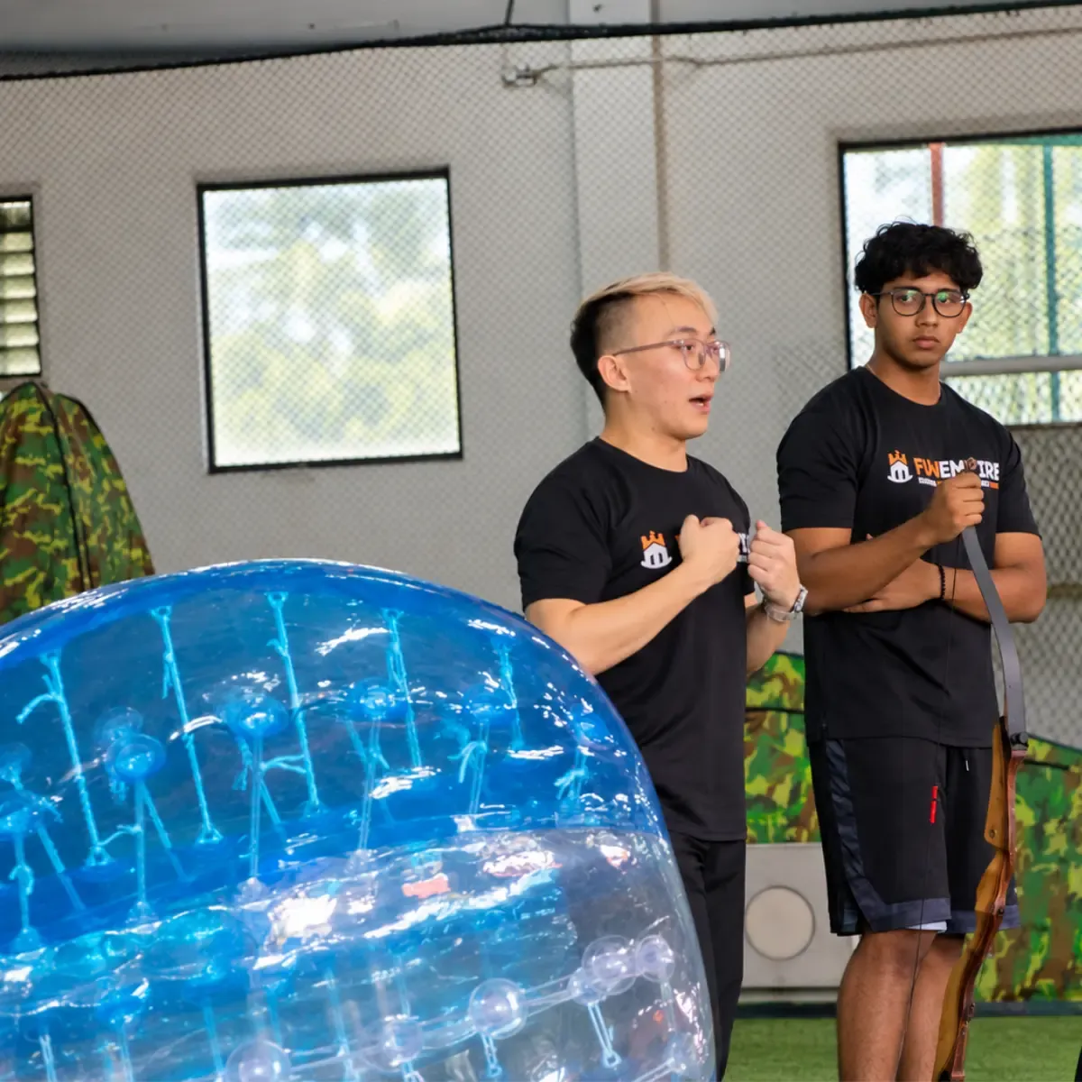 Two FunEmpire facilitators beside a bubble suit before a session
