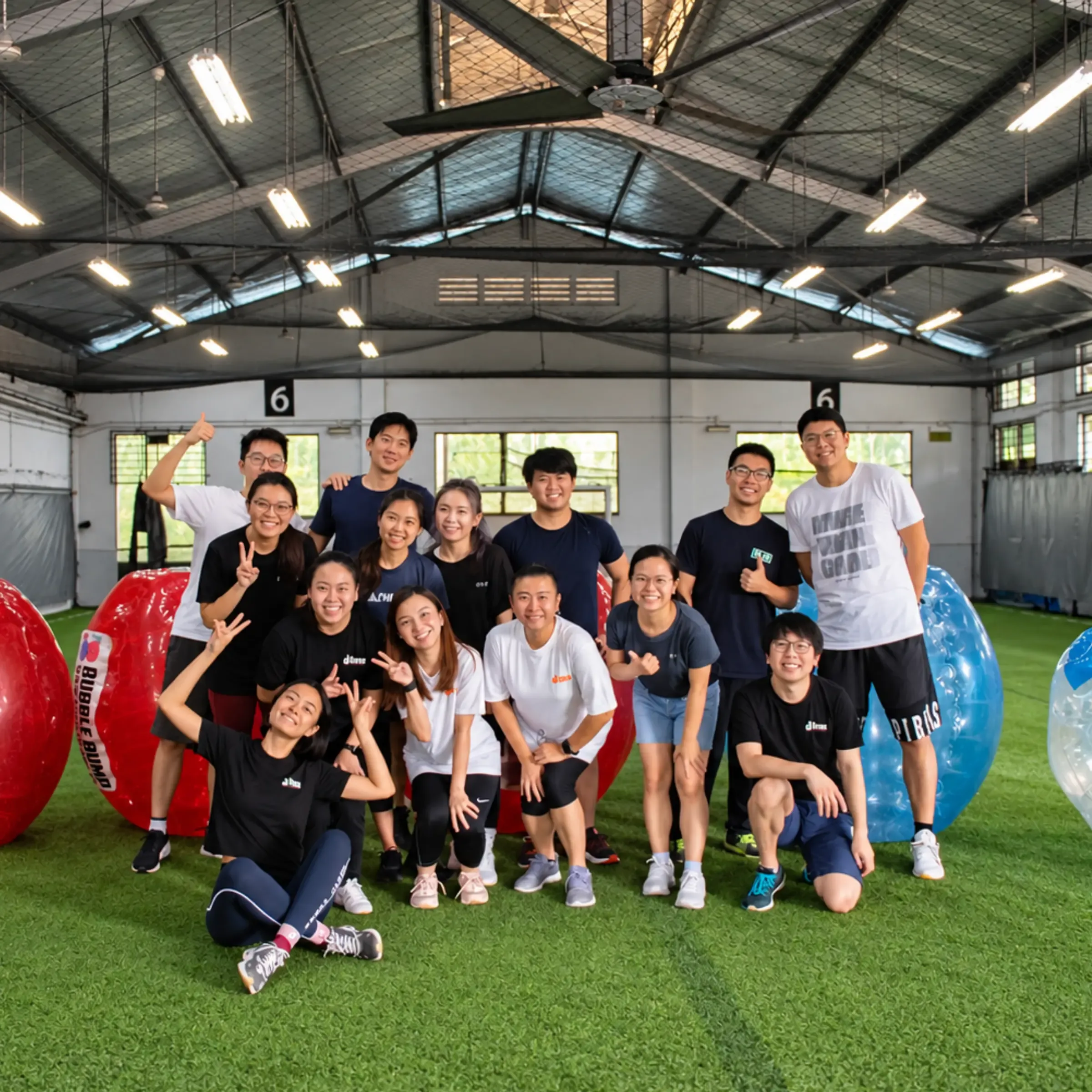 A large group poses with their bubble suits on the indoor pitch