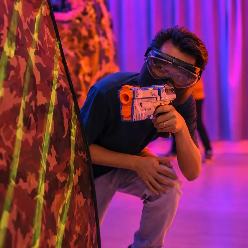 A player crouches behind a bunker, blaster in hand