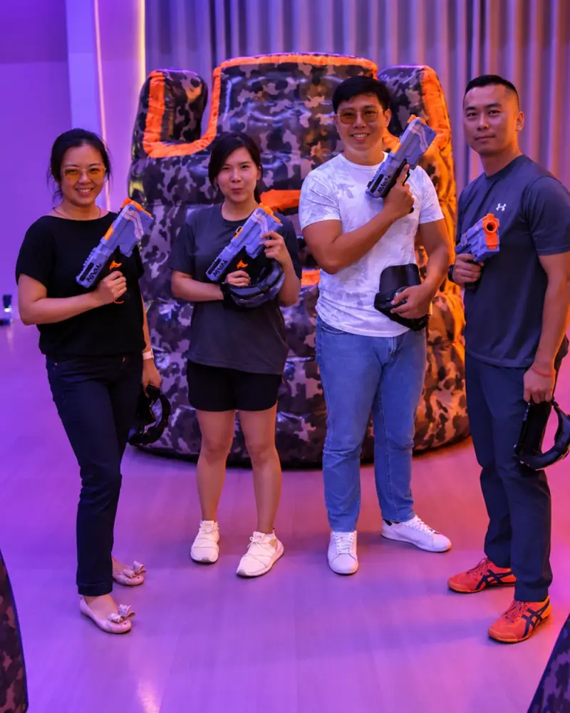 Four friends pose with their blasters in front of a bunker