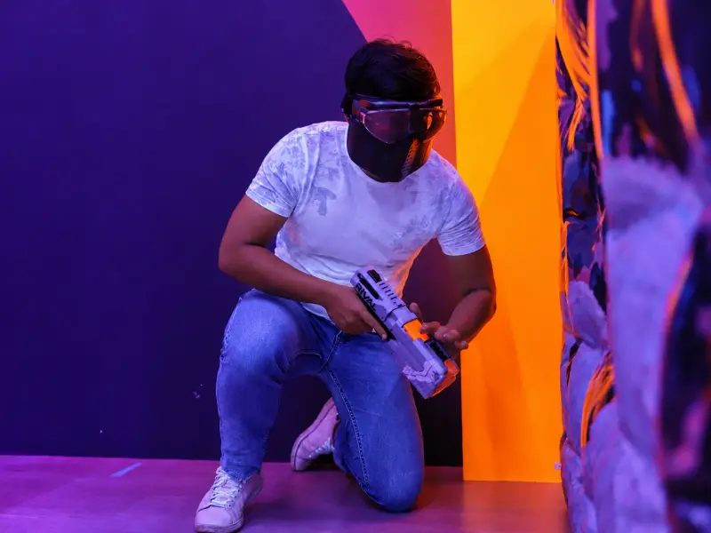 A player kneels behind cover with his blaster