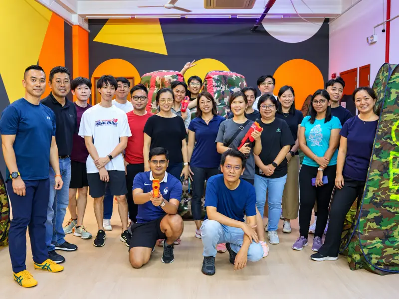 A company group of about twenty-five pose in the studio after their Bullet Strike session