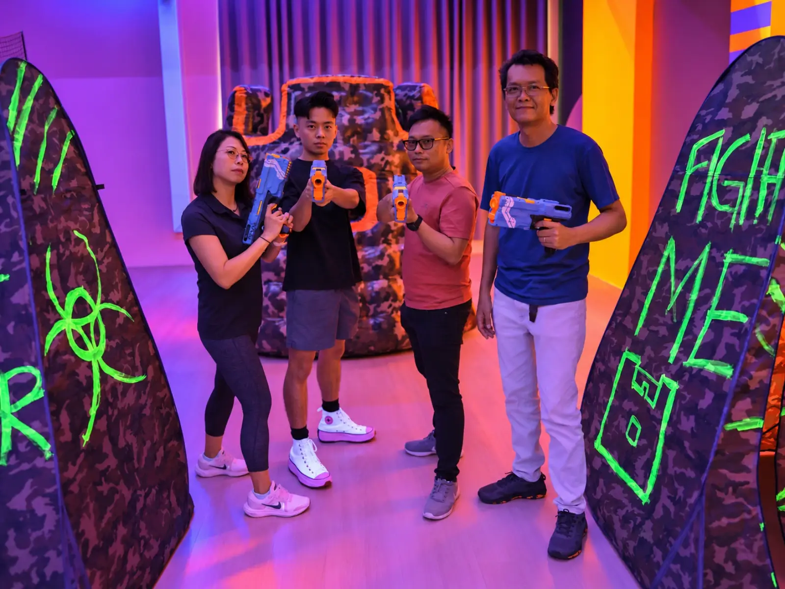 The Bullet Strike studio at FunEmpire HQ: four players stand between the neon-painted bunkers