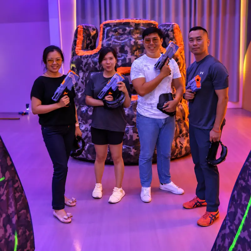 Four friends pose with their blasters in front of a bunker