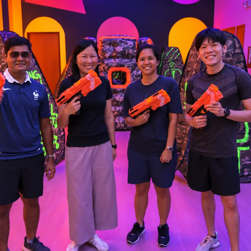Four players pose with their foam blasters between the bunkers