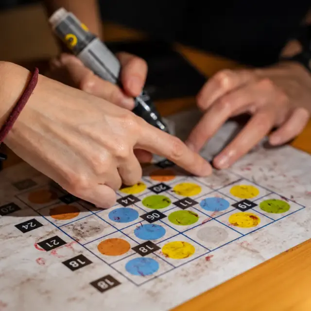 A hand marks a colour grid with a UV pen