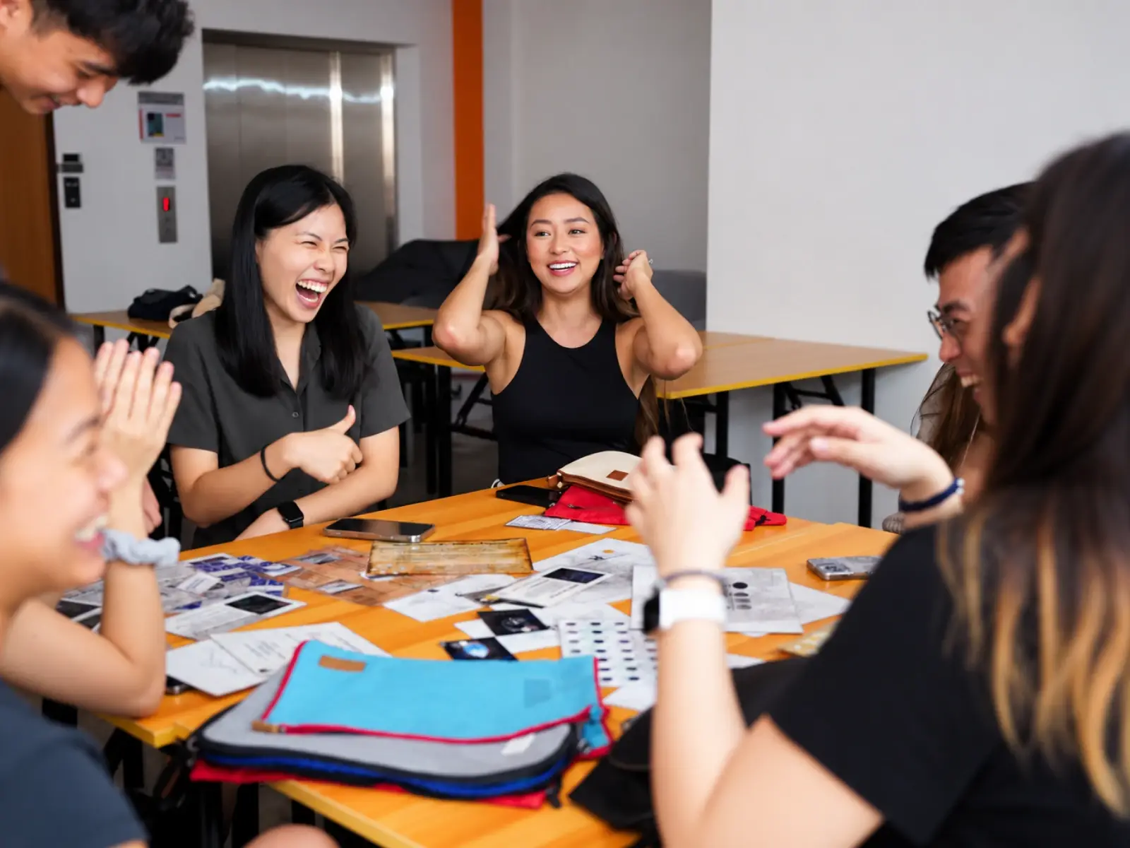 Two players burst out laughing across a table of puzzle cards