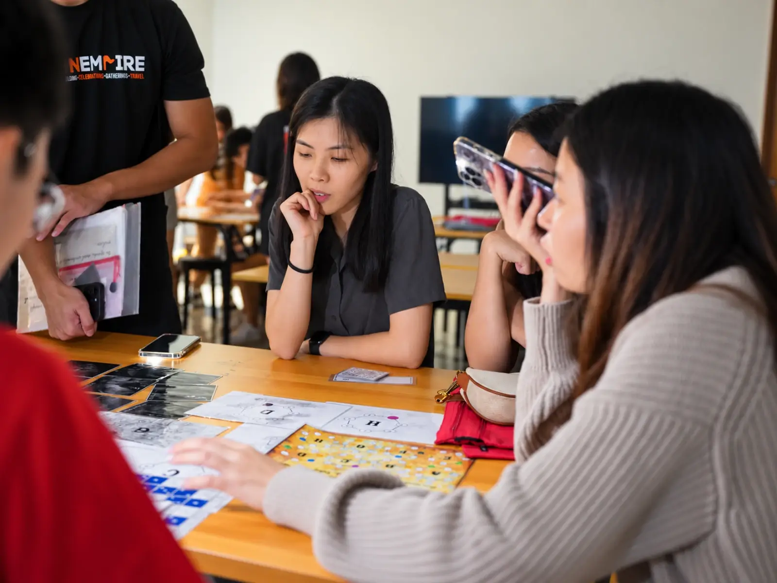 Players puzzle over the clues on their table while a FunEmpire game master stands by