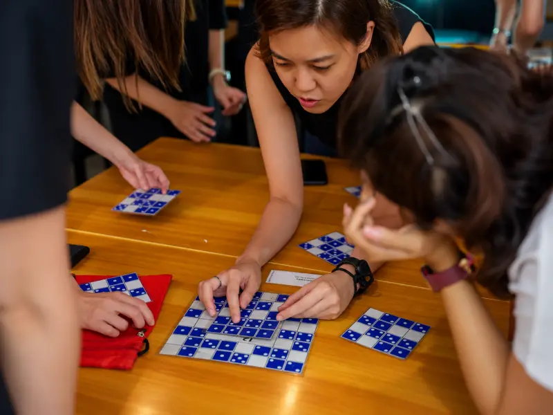 A player slides blue patterned tiles into place on the table