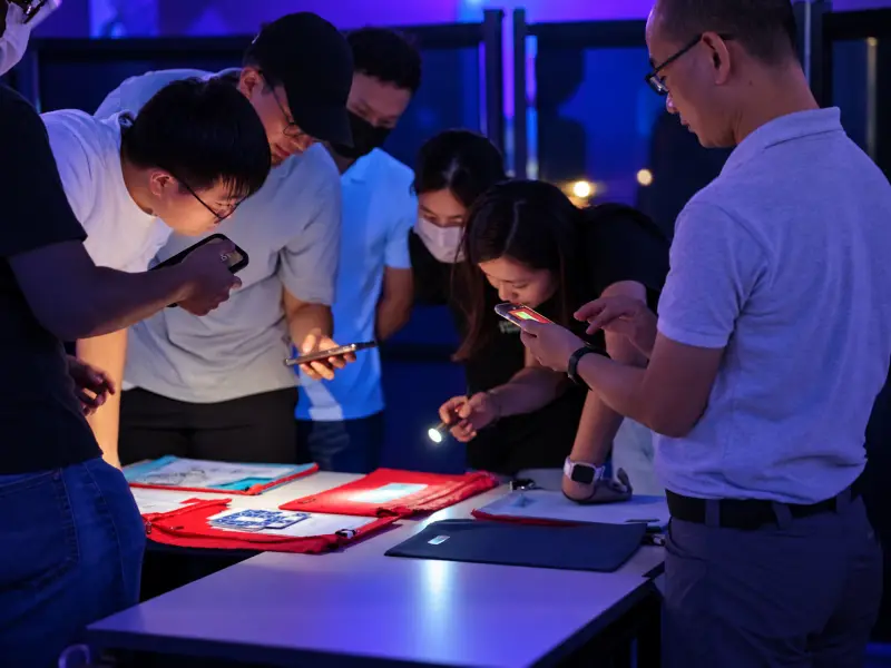 A group searches the table by phone torch in the dimmed room