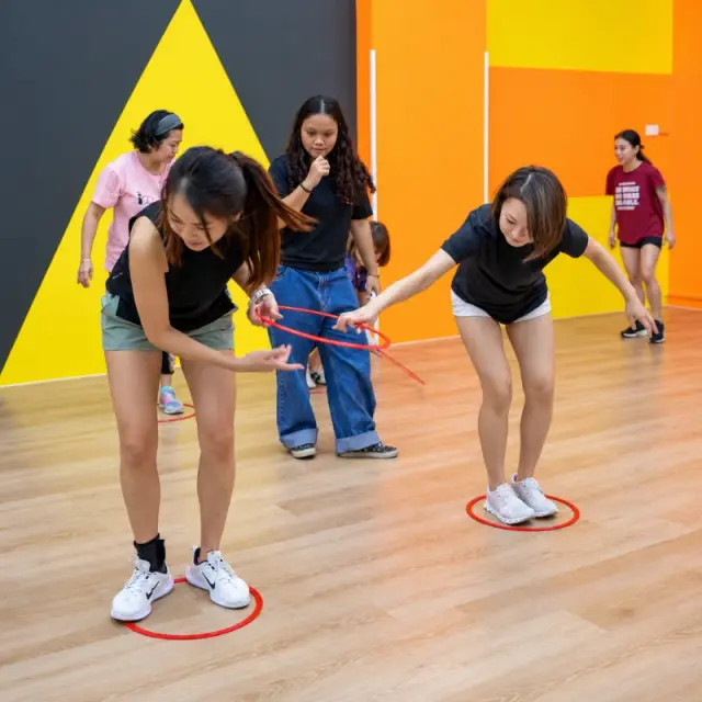 Two players pass a hula hoop along without letting go