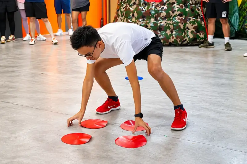 A player reaches for the red discs on the floor