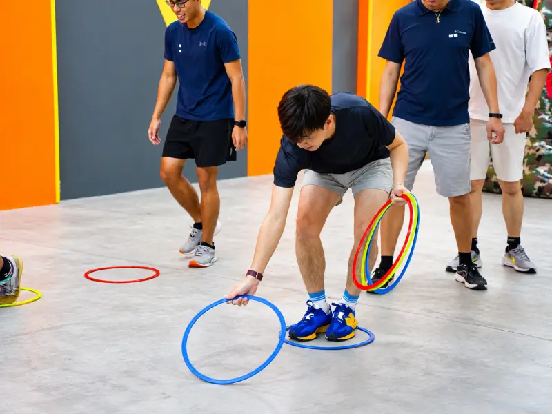 A player gathers the coloured hoops as his teammates look on