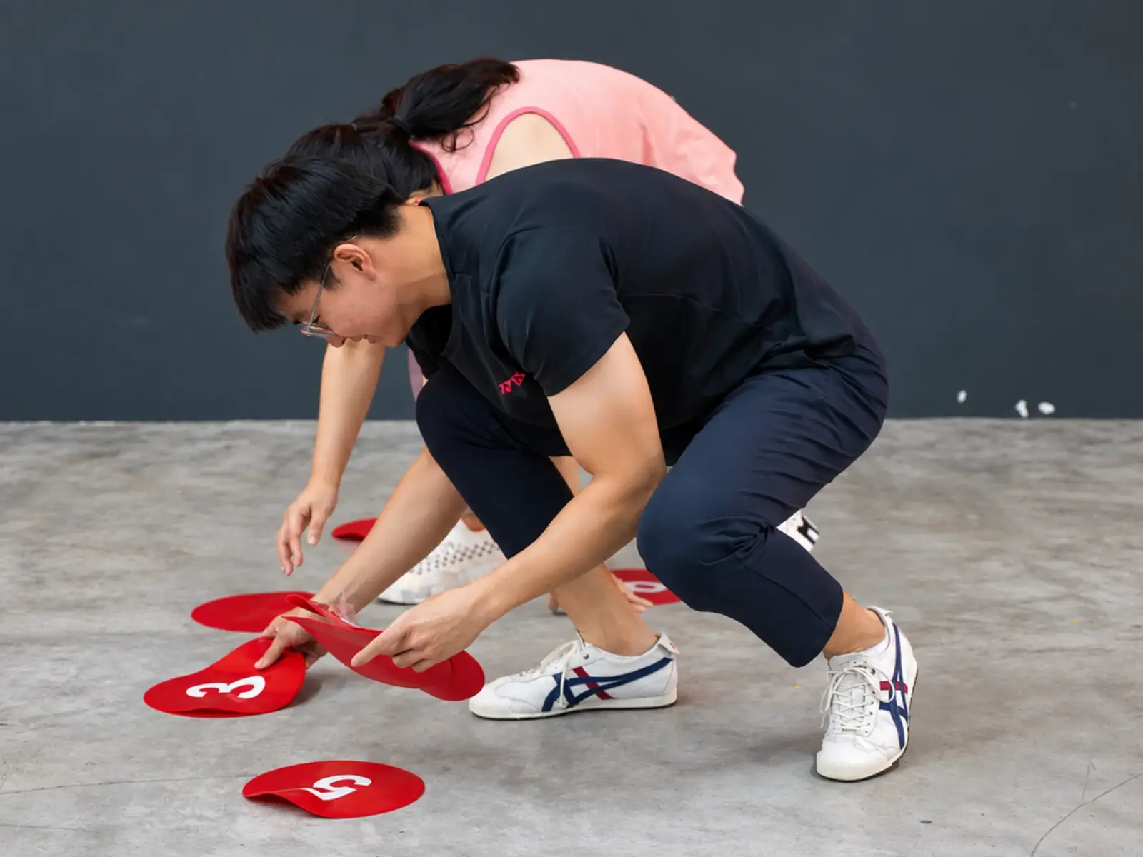 A player crouches to flip numbered markers on the floor