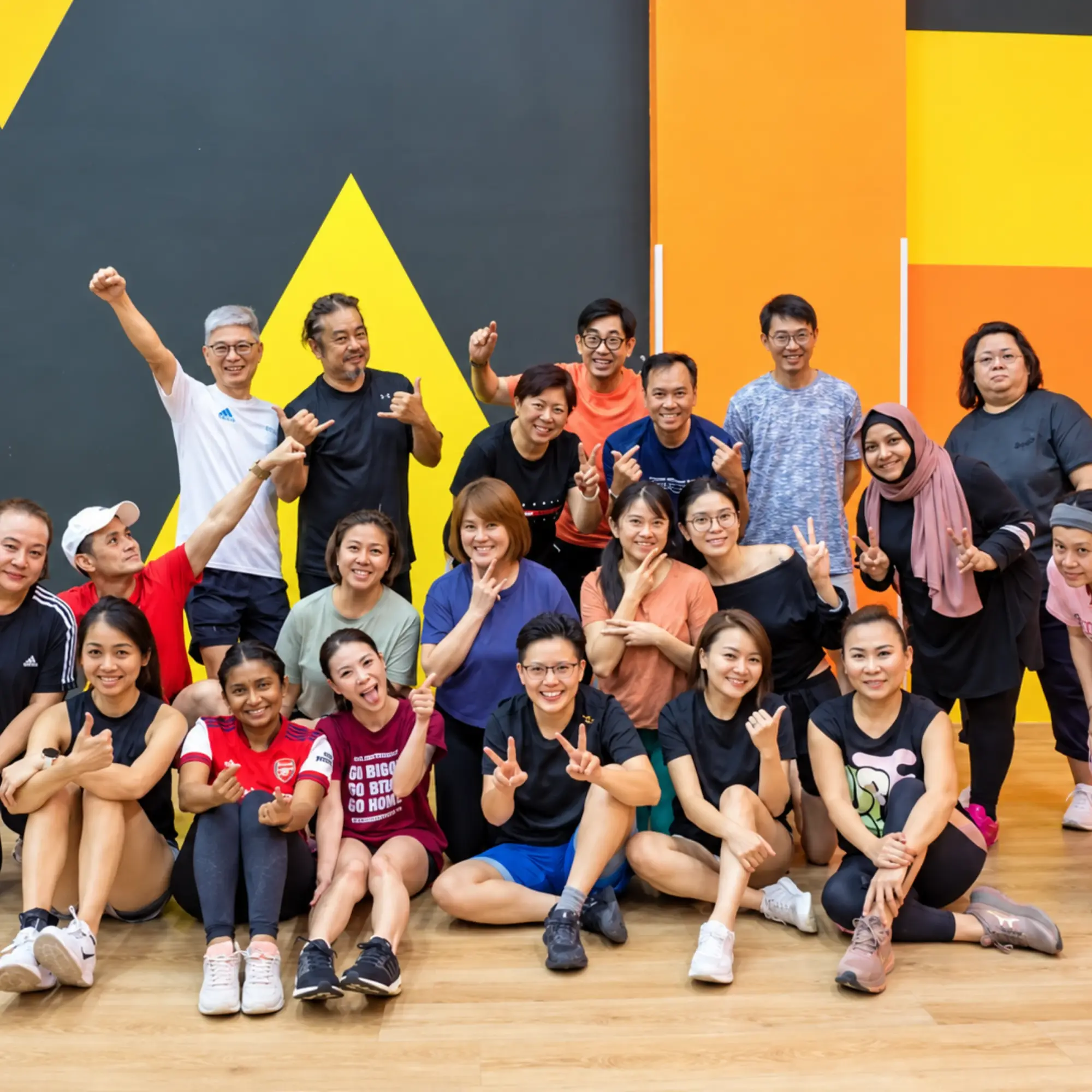 A company team of about twenty-five cheer together in the studio after their Funsical 100 session