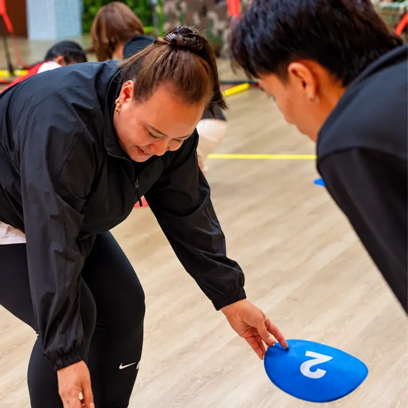 A player reaches for a numbered disc as a teammate leans in