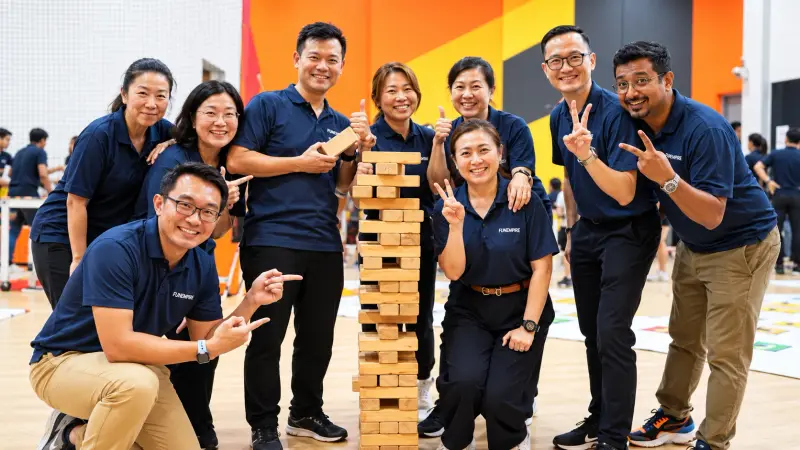 A team gathered around a giant Jenga tower at a hosted session