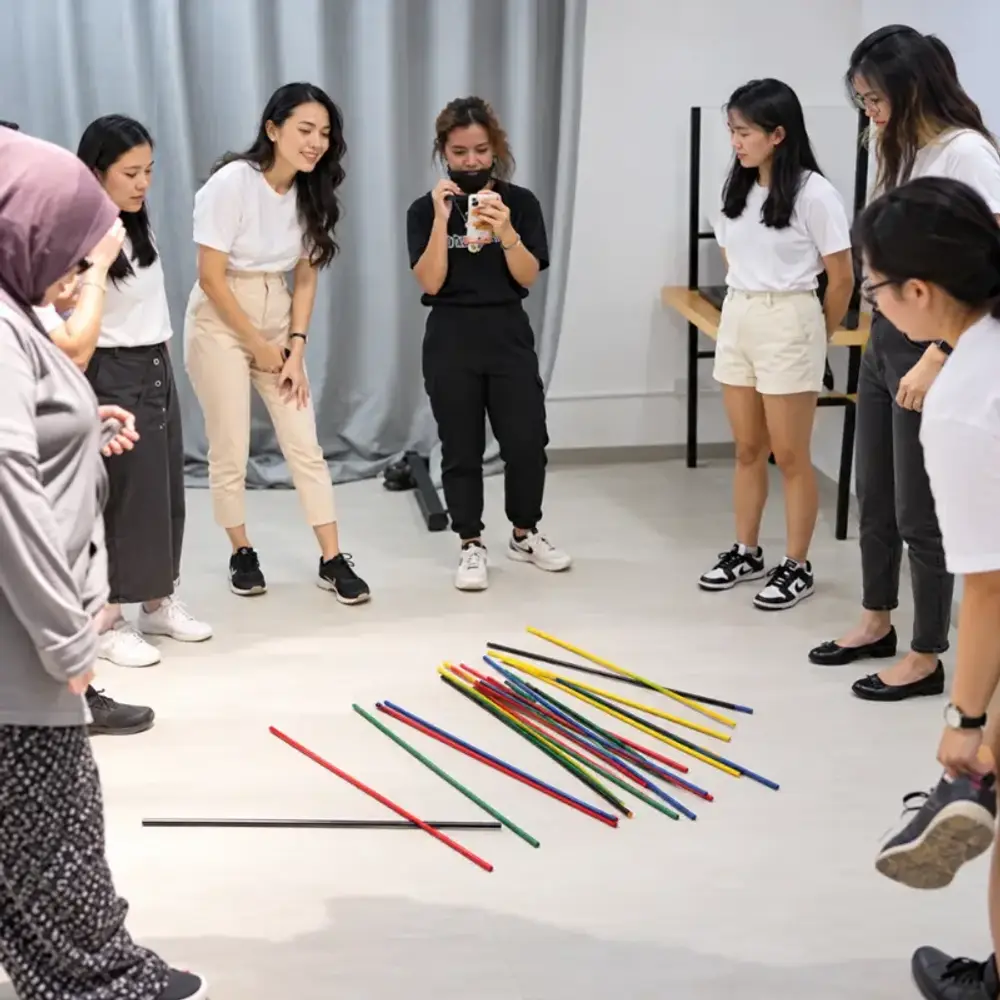 The Joy Waltz Academy group playing giant pick up sticks indoors