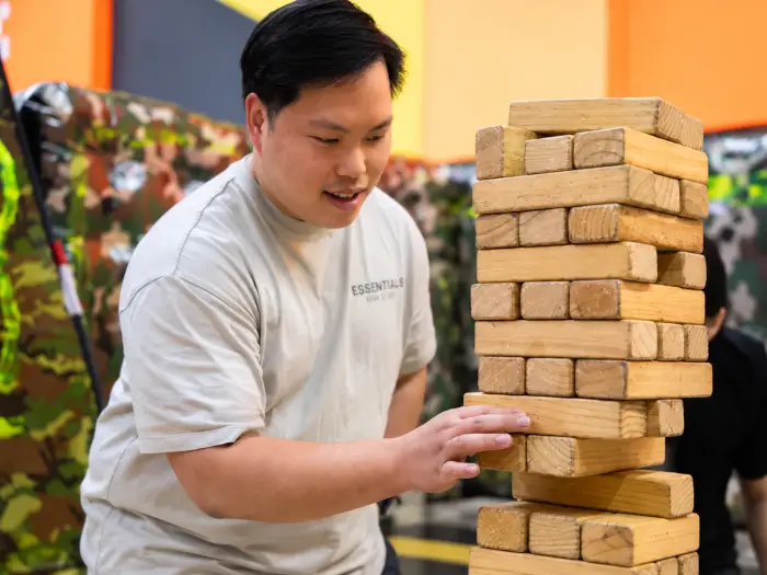 A player pulls a block from a giant Jenga tower