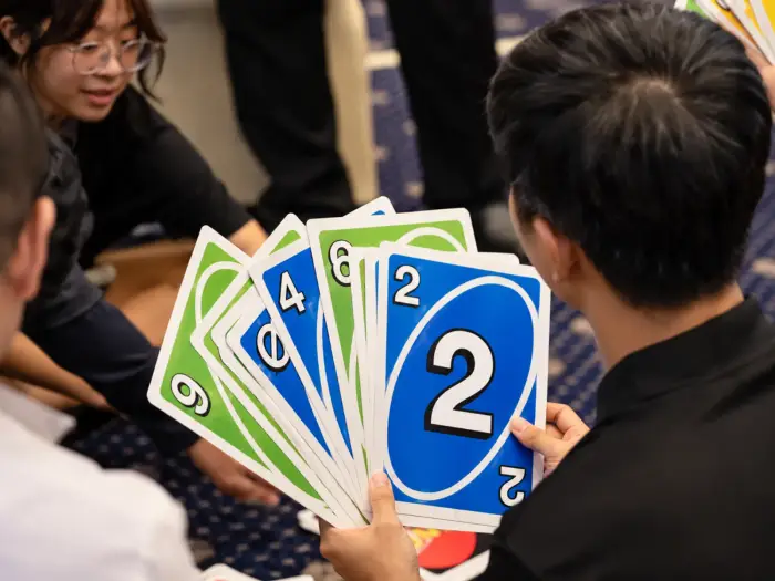 Two players hold up oversized Uno cards