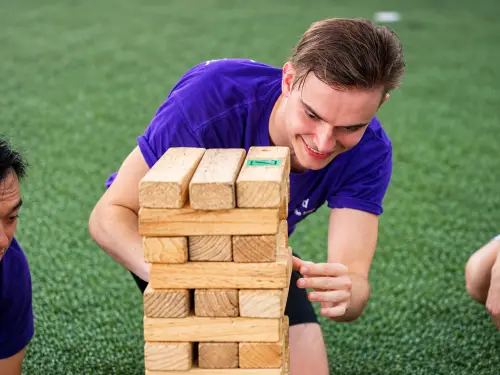 A player lines up a move on a giant Jenga tower