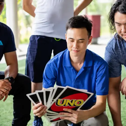 A player fans out a hand of giant Uno cards