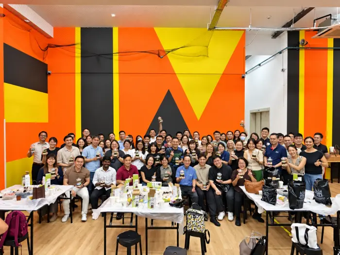 A large company group poses with the terrariums they made