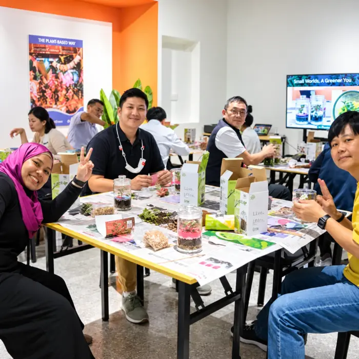A group builds terrariums at worktables during a workshop