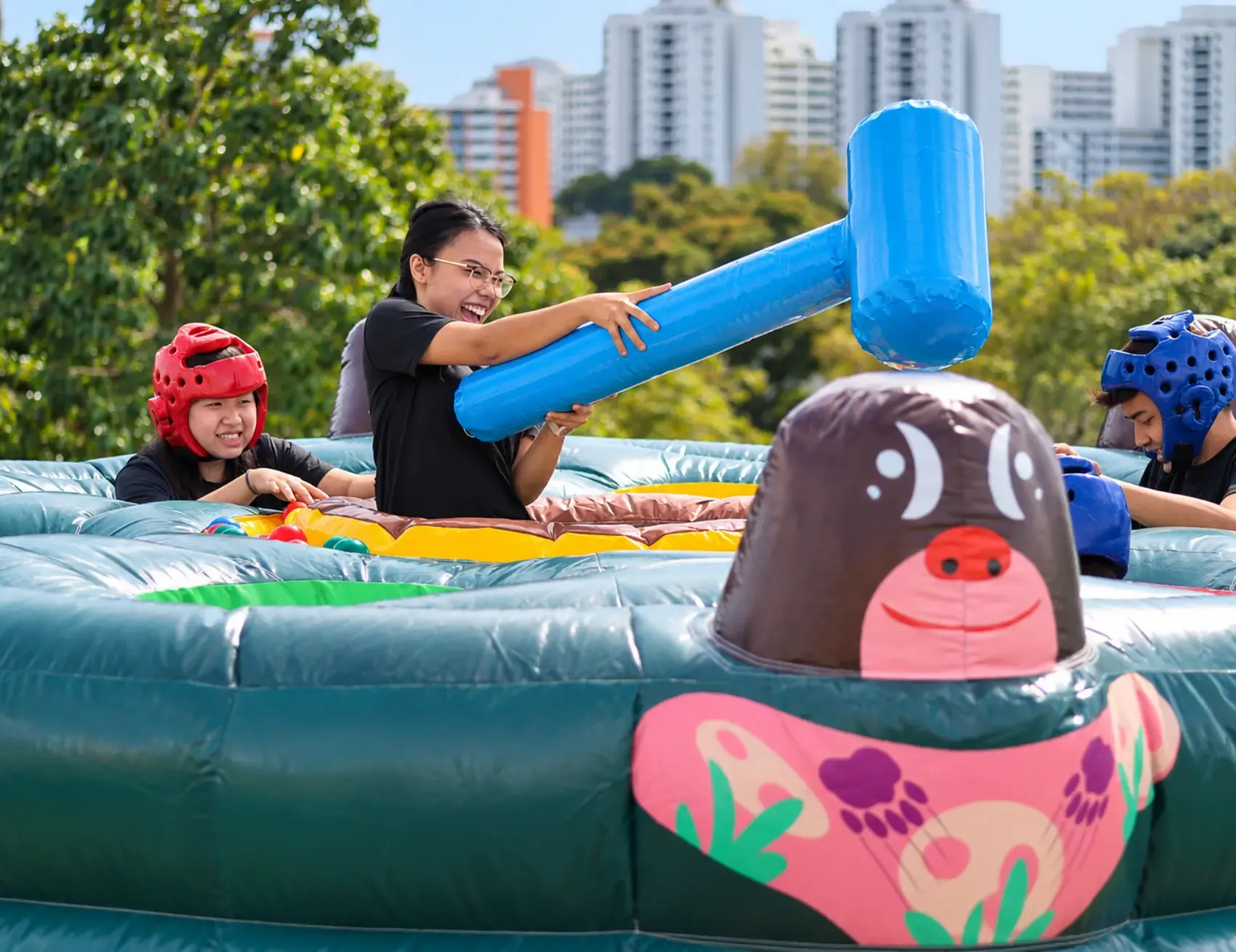 A student swings an inflatable hammer at a school carnival game