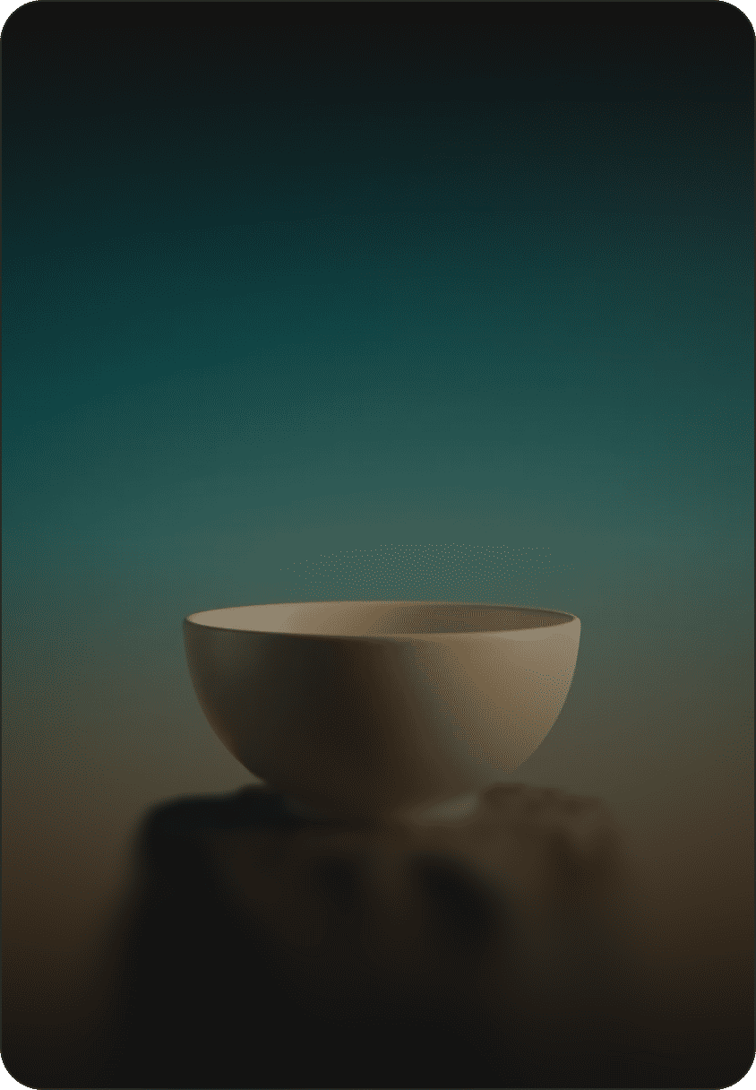Beige ceramic bowl on a rocky stone pedestal against a teal-to-orange gradient sky.
