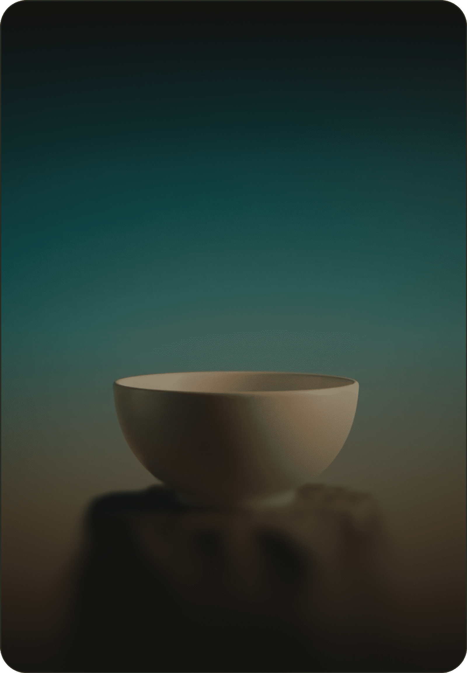 Beige ceramic bowl on a rocky stone pedestal against a teal-to-orange gradient sky.