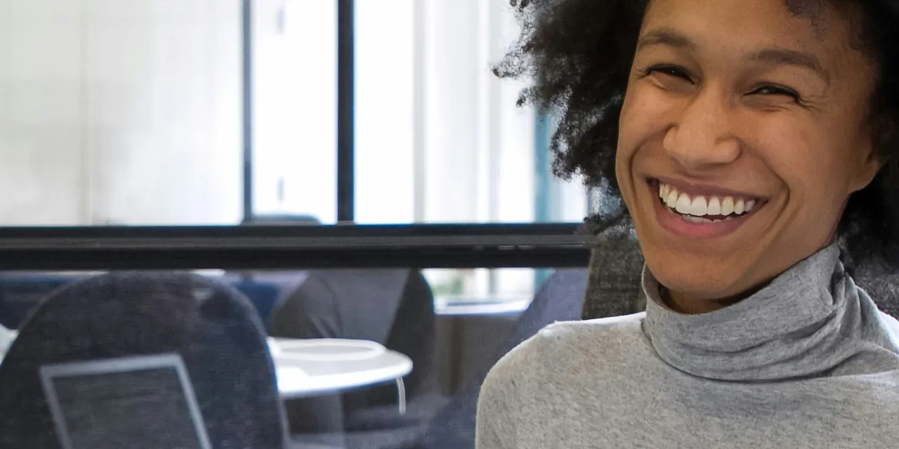 Smiling woman in office for Begin Your Career in Asset Management: Roles, Skills, and Growth Paths