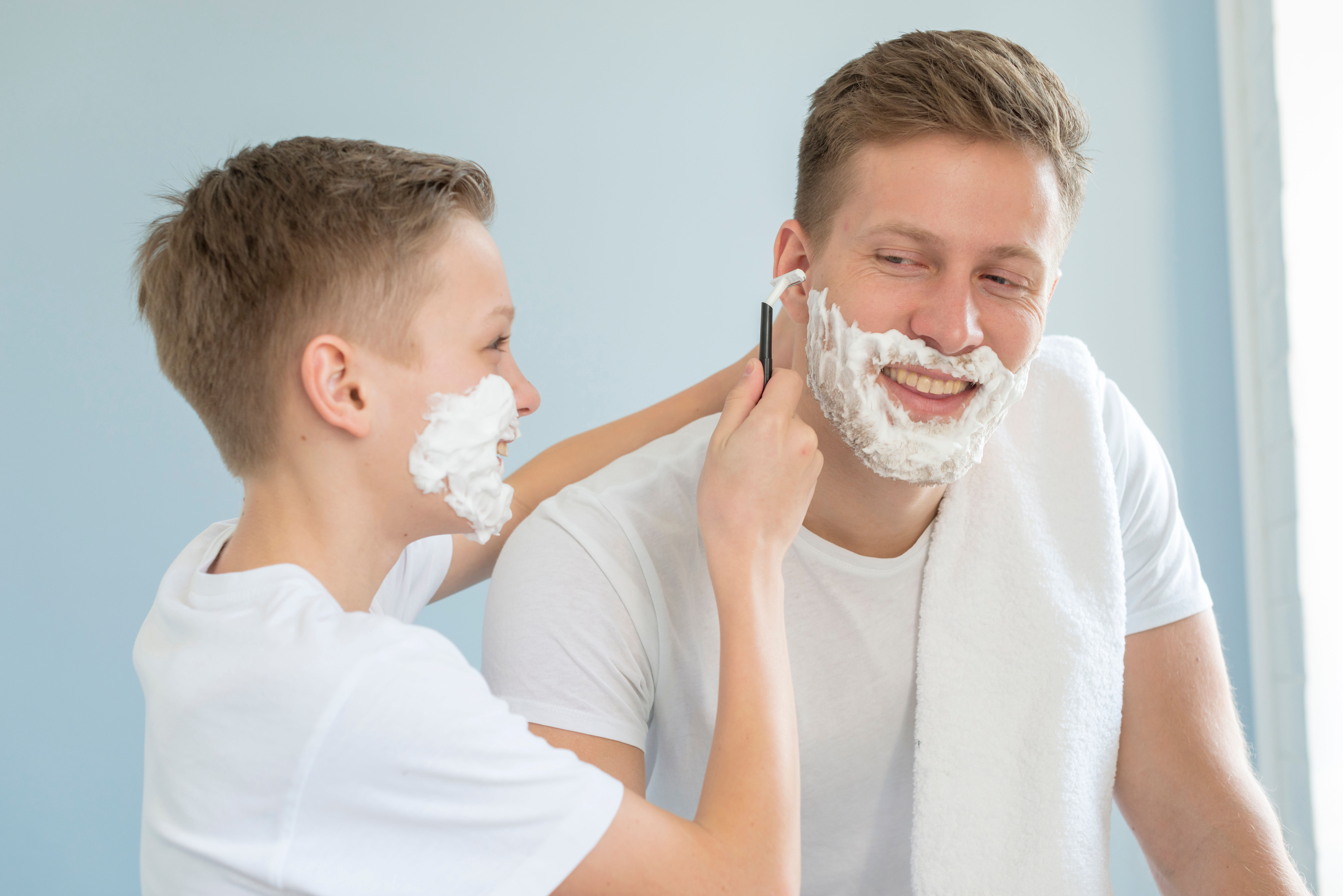 Moment de joie intime entre père et fils pendant le rasage